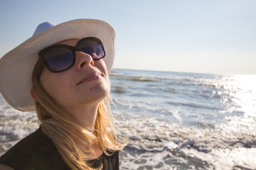 portrait of smiling woman at the beach with sunglasses