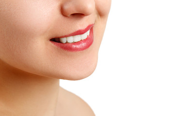 the smile of a young woman with perfect white teeth. close-up isolated on white background. place for copy space