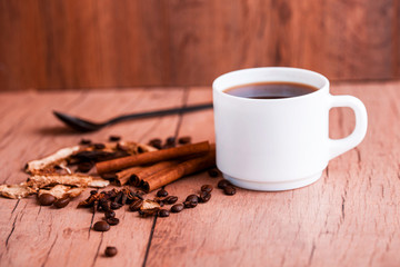 Obraz premium Fragrant natural custard coffee with cinnamon sticks, dried mushrooms, on a wooden background.