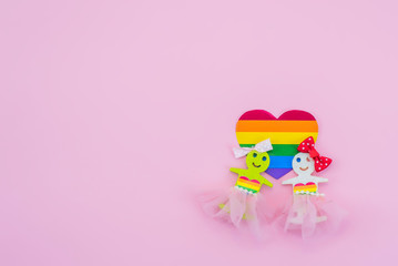LGBT figures of people. Two figures of women show unconventional orientation. Marriage and family, couple. Rights of homosexual. Pink background.