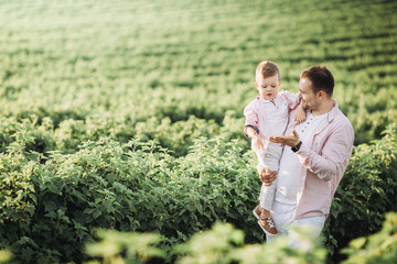 Little boy with his father on a green field
