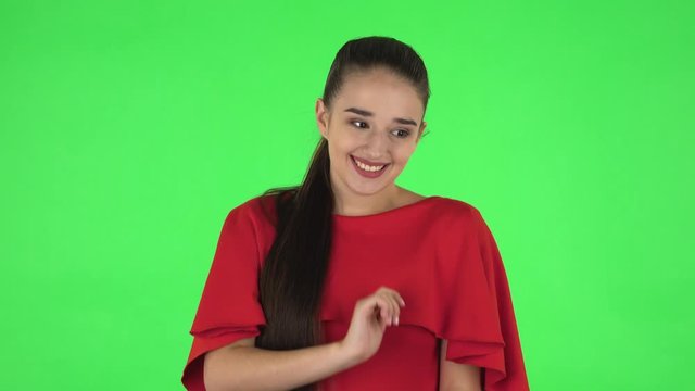 Portrait of pretty young woman confused saying oops and shrugging. Green screen