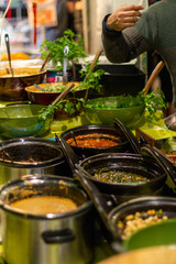 Street food, barbecuing on a hot grill with fire and smoke, thai food, vegetables and meat cooked for taking out. Brick Lane Food Market