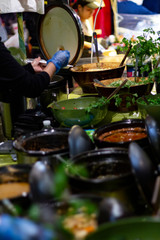 Street food, barbecuing on a hot grill with fire and smoke, thai food, vegetables and meat cooked for taking out. Brick Lane Food Market