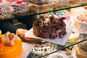 Pastry shop glass display with selection of cream or fruit cake.