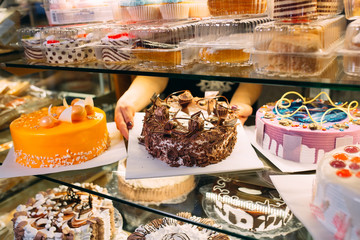 Pastry shop glass display with selection of cream or fruit cake.