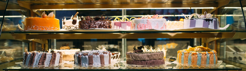 Pastry shop glass display with selection of cream or fruit cake.