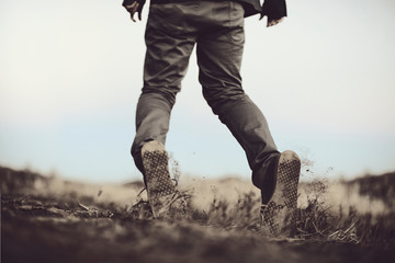 Naklejka premium Man drags his feet through the dirt, propelled by an invisible force