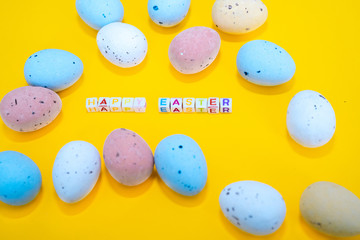 Easter greeting card with painted eggs. Seasonal Easter message  "Happy easter". Pastel and colorful   decorated easter eggs with greeting card with text on yellow background. Spring holidays concept.