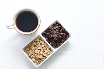Traditional cup of Colombian coffee with coffee beans on wooden background