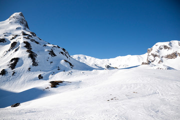 valley surrounded of mountains in a sunny day covered of snow