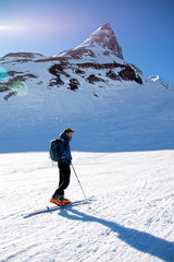 man waiting in the mountains in a sunny day while skiing
