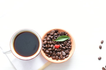 Traditional cup of Colombian coffee with coffee beans on wooden background