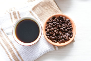 Traditional cup of Colombian coffee with coffee beans on wooden background