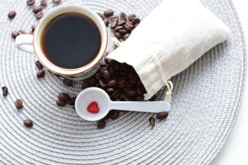 Traditional cup of Colombian coffee with coffee beans on wooden background