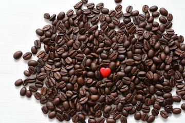  Processed coffee beans and tostao, with red heart on wooden background