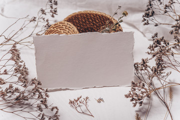 Wedding invitation mockup with dry plants , papers on white textile background. Top view, flat lay. Wedding stationary. Perfect for presentation of your invitation, menu, greeting cards