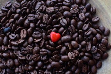  Processed coffee beans and tostao, with red heart on wooden background