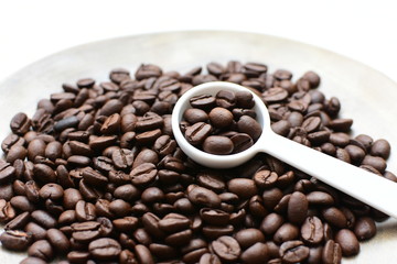 Processed coffee beans and tostao, on wooden background