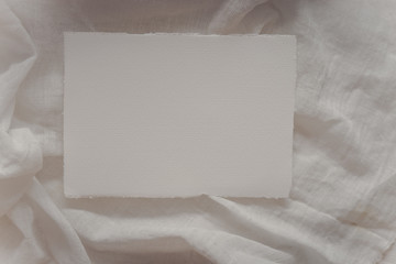 Wedding invitation mockup with paper, dry branches on white textile background. Top view, flat lay. Wedding stationary. Perfect for presentation of your wedding invitation, menu, greeting cards