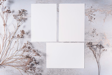 Wedding invitation mockup with dry plants , papers on stone background. Top view, flat lay. Wedding stationary. Perfect for presentation of your invitation, menu, greeting cards. Winter concept