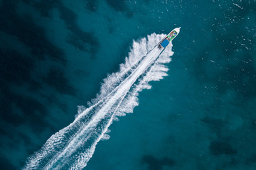 Bird eye view of motor boat with wake at sea - Powered by Adobe