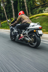 Obraz premium Rowerzysta w czerwonym kasku na rowerze. widok z tyłu