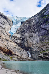 The Briksdalsbreen (Briksdal) glacier, which is the sleeve of the large Jostedalsbreen glacier in Norway. The melting glacier forms the Briksdalsbrevatnet lake with clear water.