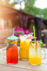 Summer yellow-orange lemonade with ice . Refreshing lemonade with oranges and mint on a wooden table