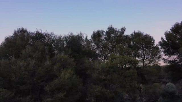 despegue de drone desde el suelo avanzando entre las monta&ntilde;as para desvelar un peque&ntilde;o pueblo en la llanura