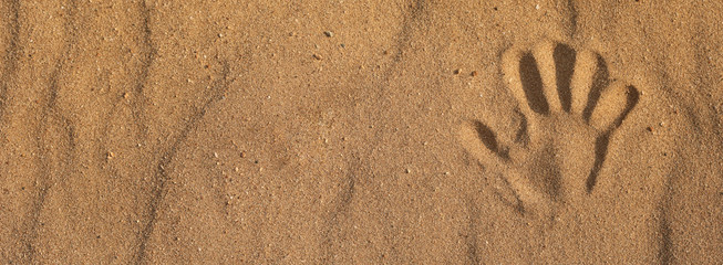 baner handprint on the sand on the beach. copy space