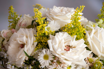 Floral arrangement for wedding, beautiful white roses and yellow details on outdoor table...