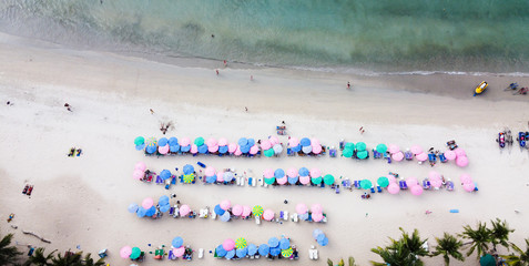 Aerial view of Tourists on the sand beach, colorful umbrellas.