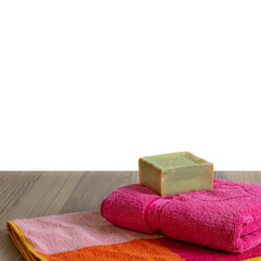 Organic soap with towels on table, copy space for text. Traditional olive oil soap. Handmade and healthy soap bar.