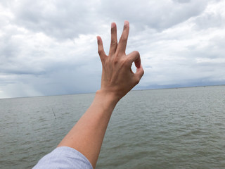 hand ok sign on blue sky background.