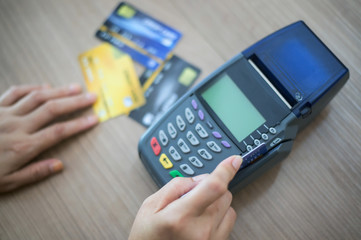 The store staff is swiping a credit card to pay for the product. Concept of payment using a debit card.