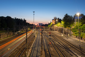 Fototapeta na wymiar train leaving light trails on rail yard junction at sunset