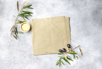 Food background with linen napkin, olive tree branch, olive oil on concrete background