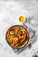 Seafood Spaghetti with seashells, prawns, squids on gray background. Italian mediterranean food concept