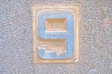 Number 9, nine, stone relief in light tone.