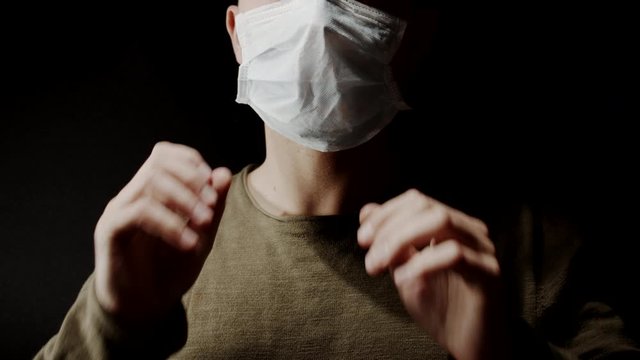 Unrecognizable male puts on face protection mask to protect from viruses 