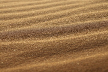 sand texture - background of desert sand dunes. Beautiful structures of sandy dunes. sand with wave from wind in desert - Close up