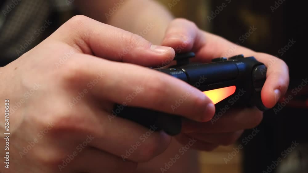 Poster close-up of man's hands holding a remote control from a game console and playing video games. concep