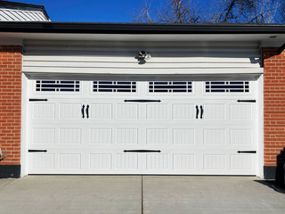Custom carriage looking ribbed panel garage door with windows and barn door decorations.