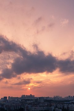 Vertical Aerial Shot Of A Pink And Orange Sky At Sunset Above A Big City