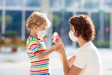Mother and child with face mask and hand sanitizer