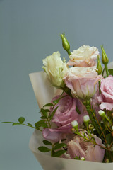 Detail closeup of romantic bridal or congratulatory bouquet, light gray background, selective focus