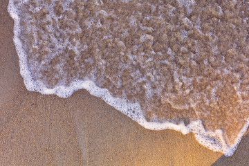 Top view Soft wave from sea come to wet sand beach background. With copy space for text or design