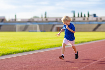 Fototapeta premium Child running in stadium. Kids run. Healthy sport.