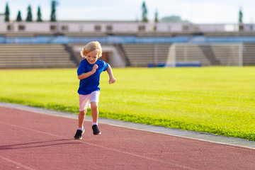 Child running in stadium. Kids run. Healthy sport.